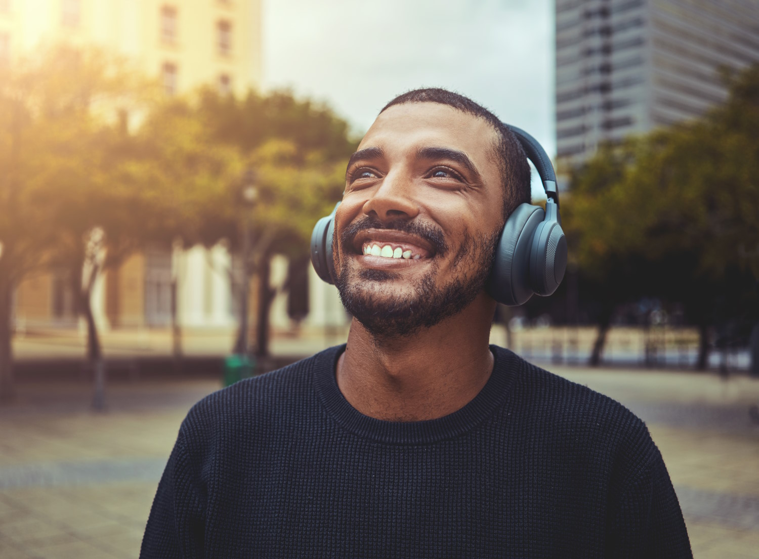 Hombre escucha música en la calle con auriculares inalambricos